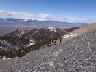 Climbing scree, with the Lost River Range in the background.